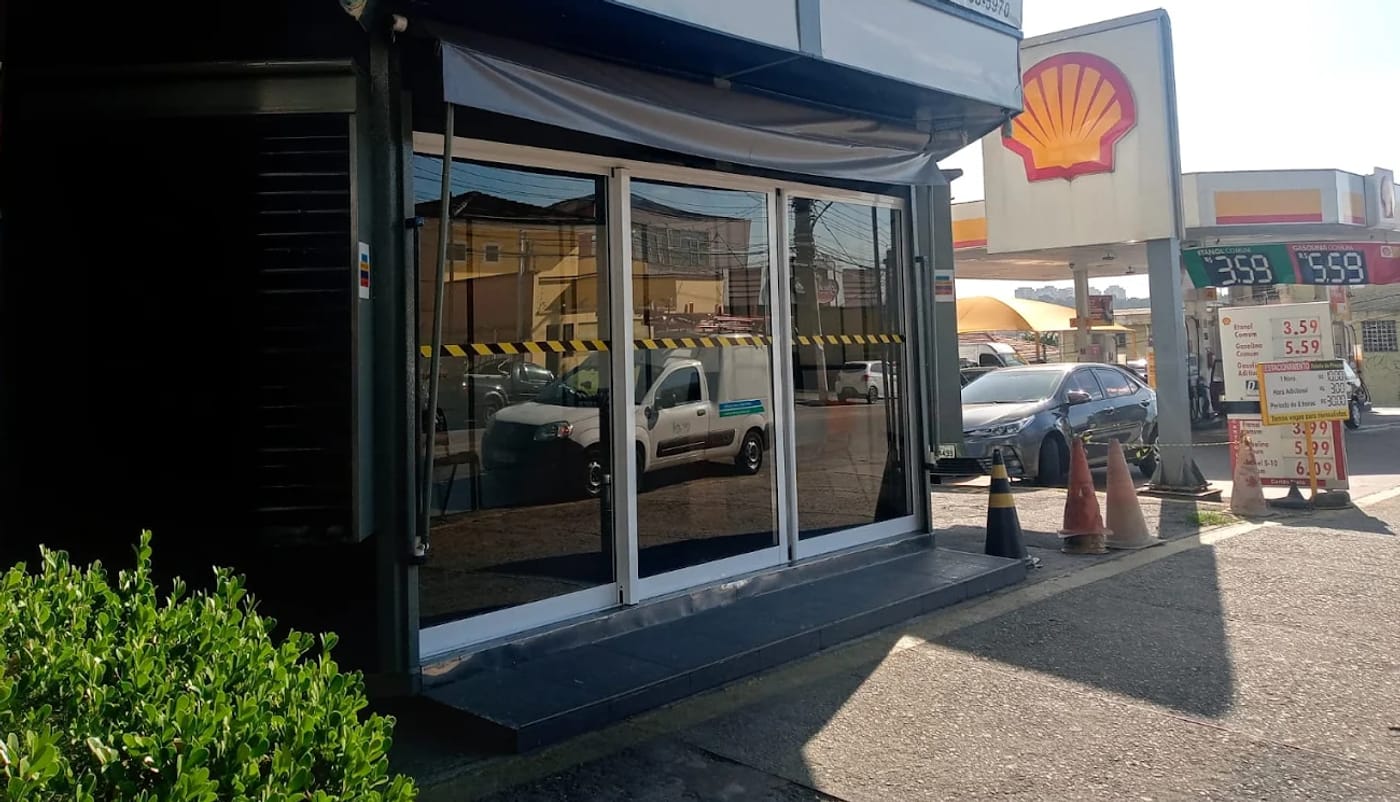 Fachada do escritório da GINT Despachante na Av. Nossa Sra. da Assunção, no Butantã, com vitrine de vidro e entrada pela calçada.